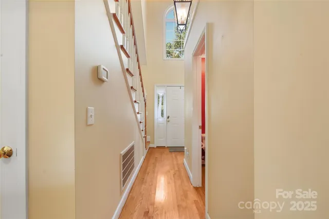 a view of a hallway with wooden floor and staircase