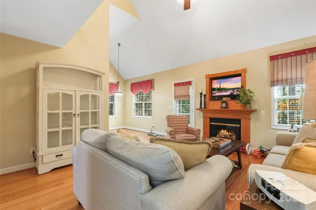 a living room with furniture a fireplace and a floor to ceiling window