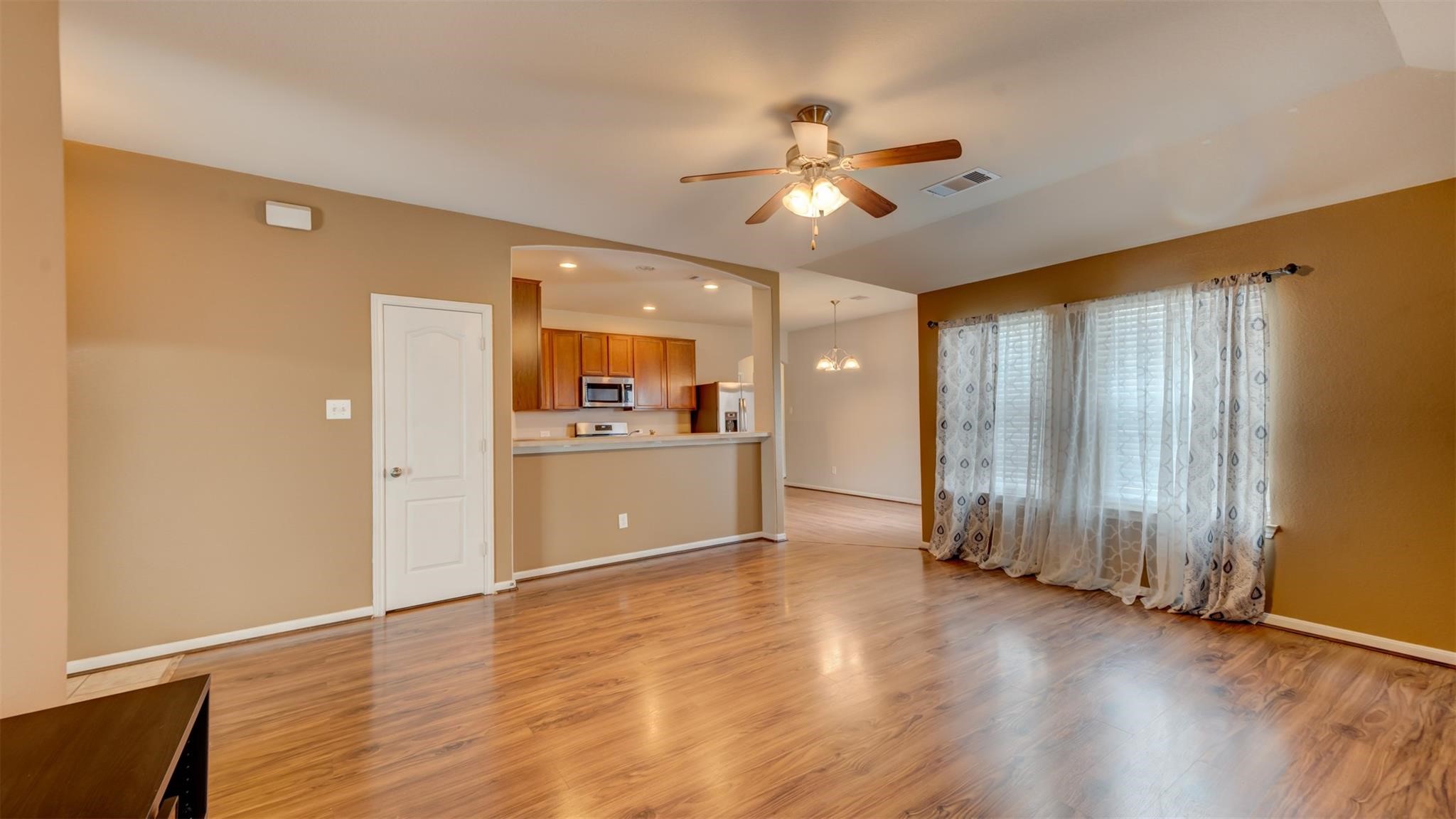 2831 Lockeridge Bend Drive Spring, TX 77386 - Photo 4 of 16 a view of a kitchen with wooden floor and a ceiling fan