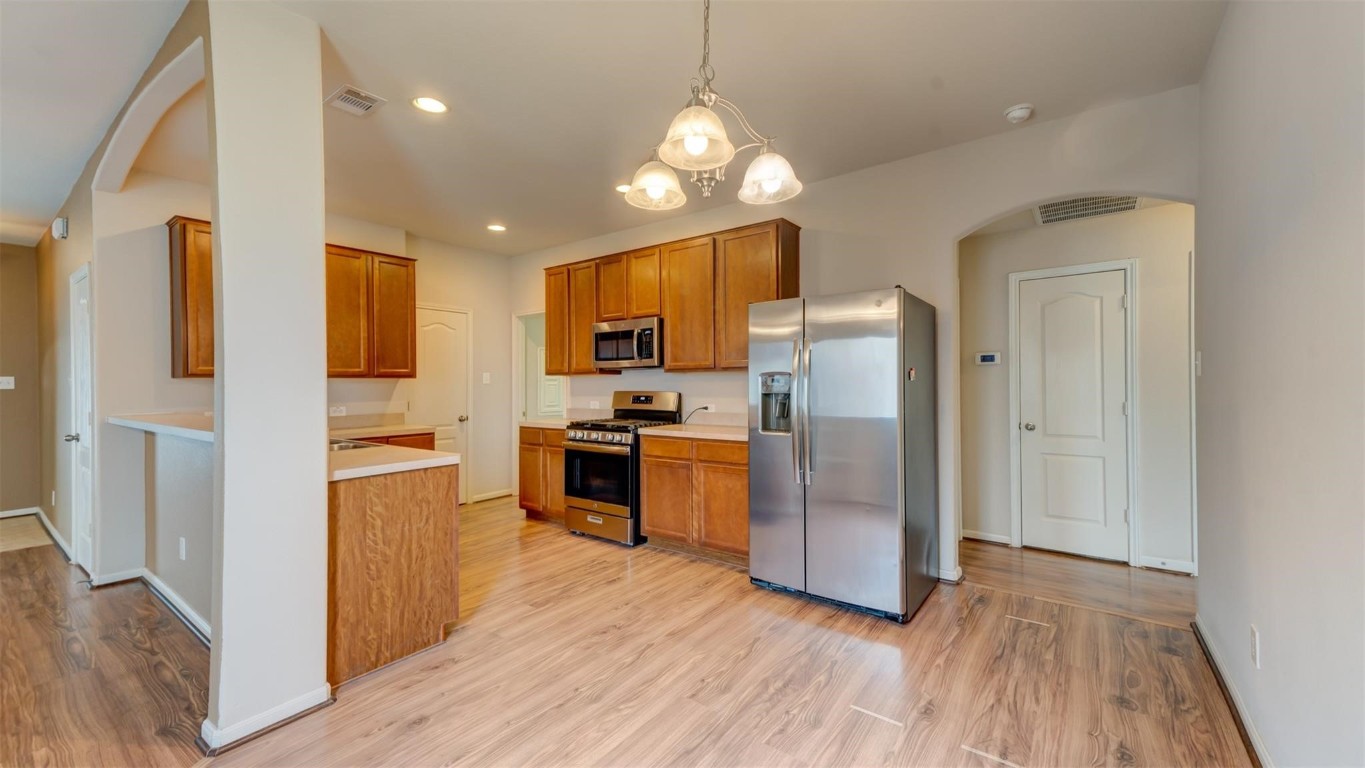 2831 Lockeridge Bend Drive Spring, TX 77386 - Photo 7 of 16 a kitchen with refrigerator a microwave and wooden floor