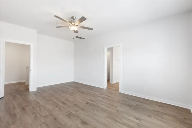 a view of an empty room with wooden floor