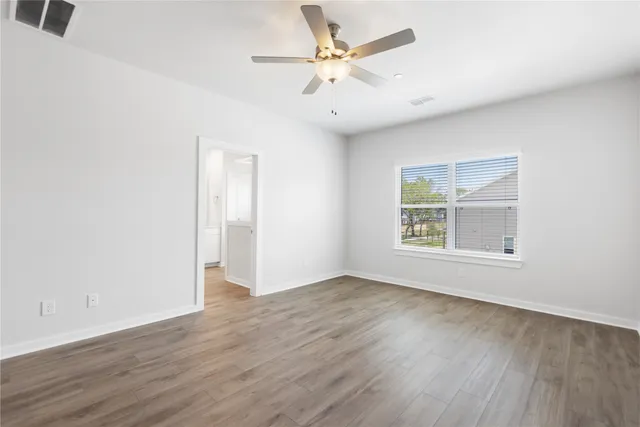 wooden floor in an empty room with a window