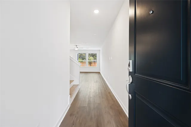 a view of a hallway with wooden floor and staircase