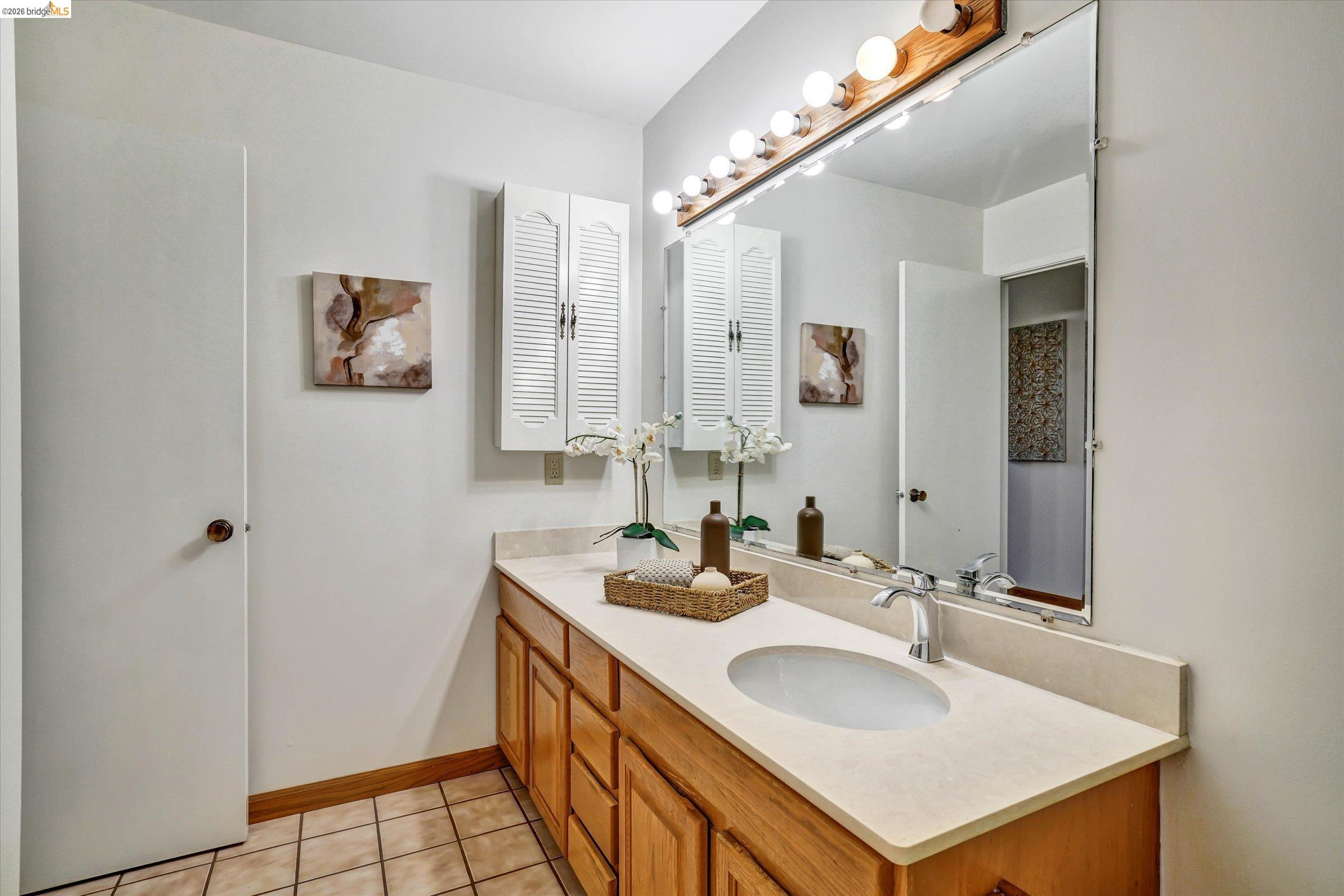 2826 Wright Avenue Pinole, CA 94564 - Photo 48 of 70 Bathroom vanity featuring a light wood-finish cabinet with multiple drawers, a beige countertop with an integrated oval sink, and a chrome faucet