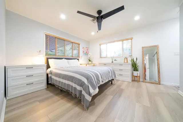 a bedroom with a large bed and a chandelier