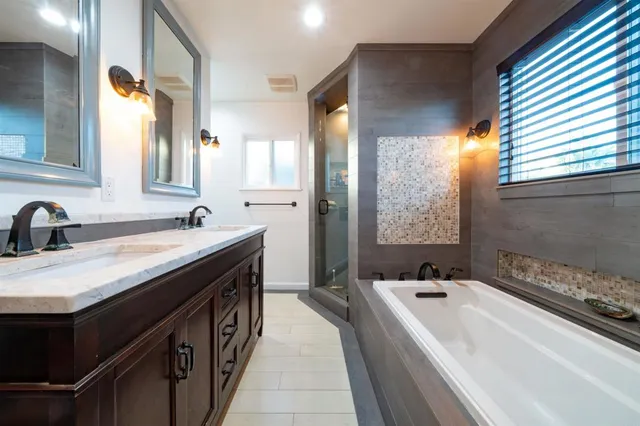 a spacious bathroom with a bathtub sink and mirror