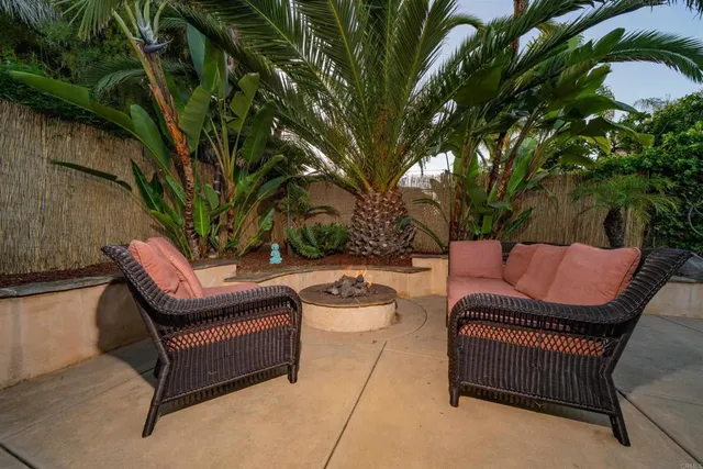 a backyard of a house with fire pit and outdoor seating