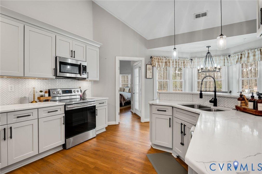6109 Autumn Bluff Road Powhatan, VA 23139 - Photo 10 of 28 a kitchen with stainless steel appliances granite countertop a stove sink and cabinets