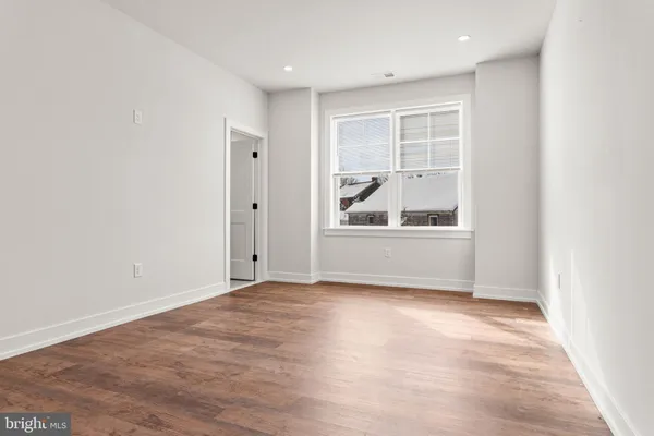 an empty room with wooden floor and cabinet