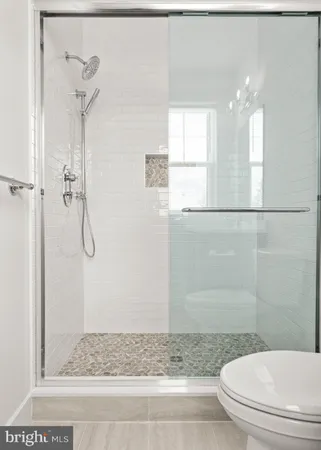 a bathroom with a granite countertop sink a toilet and shower