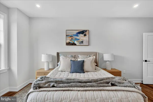 a bedroom with a bed and painting on the wall