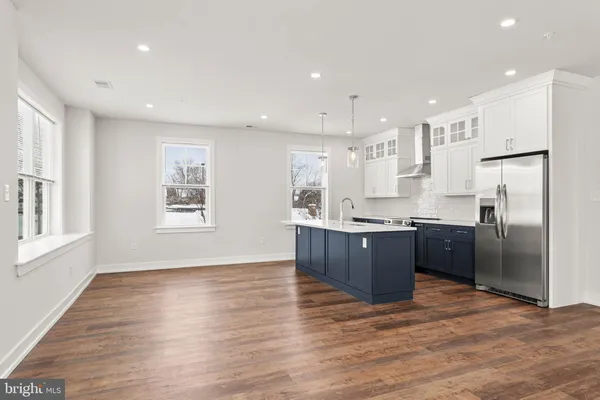 a large kitchen with stainless steel appliances granite countertop a large counter top a sink a refrigerator and a window