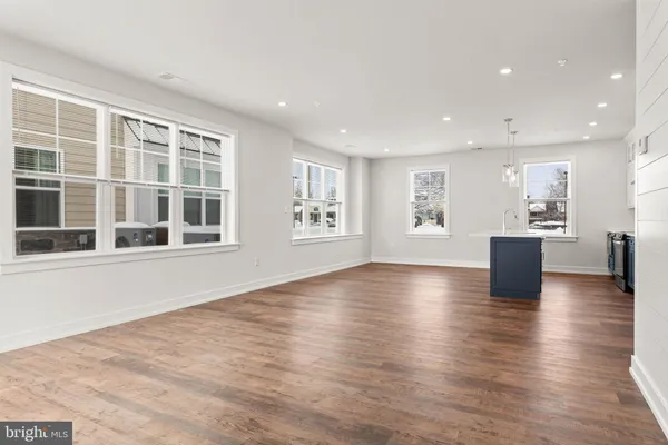 a view of empty room with wooden floor and windows