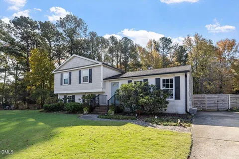 a front view of a house with a yard and trees