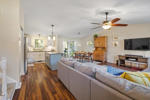 a living room with stainless steel appliances furniture and a flat screen tv