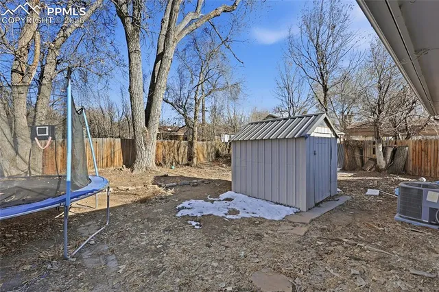 a wooden house with a yard and wooden fence