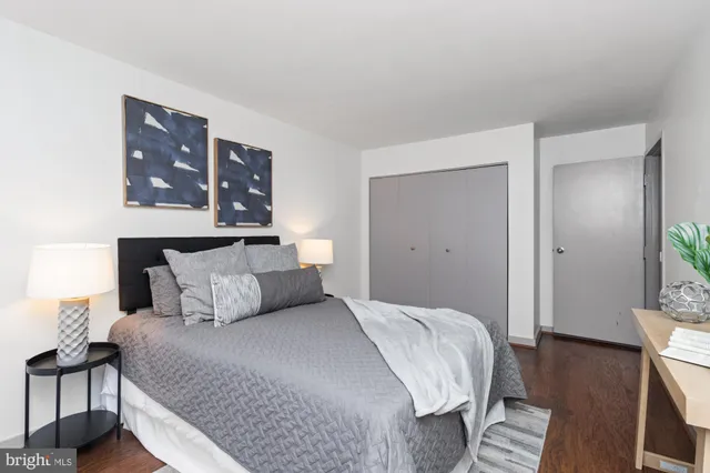 a bedroom with a large bed and wooden floor