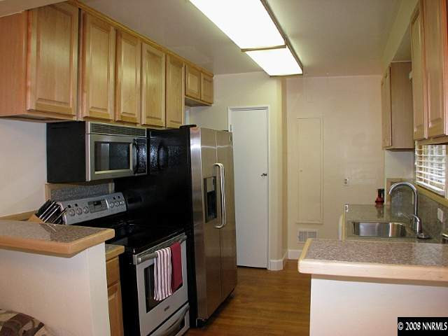 1374 Lander Street Reno, NV 89509 - Photo 4 of 9 a kitchen with stainless steel appliances granite countertop a sink stove and refrigerator