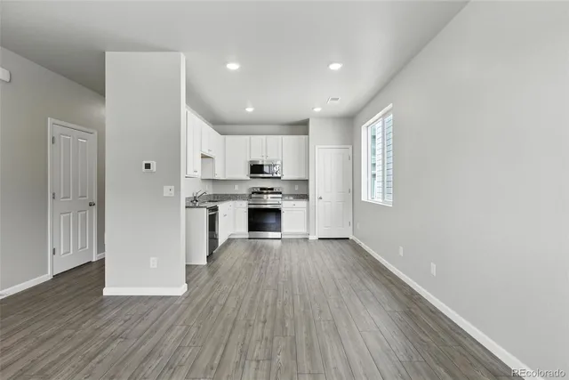a view of kitchen with wooden floor electronic appliances and window