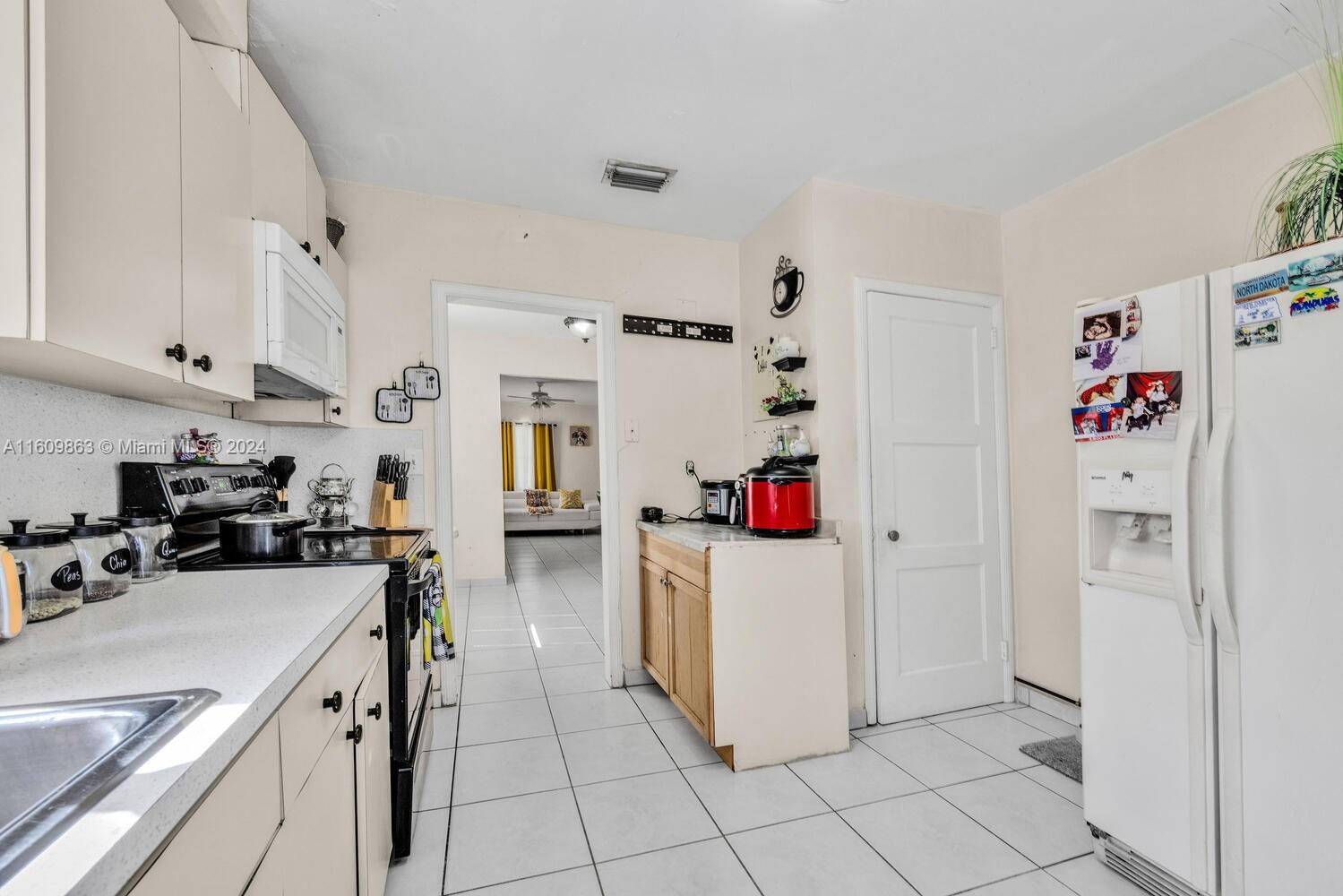 3430 Southwest 11th Street Miami, FL 33135 - Photo 16 of 21 a kitchen with a sink a refrigerator and cabinets
