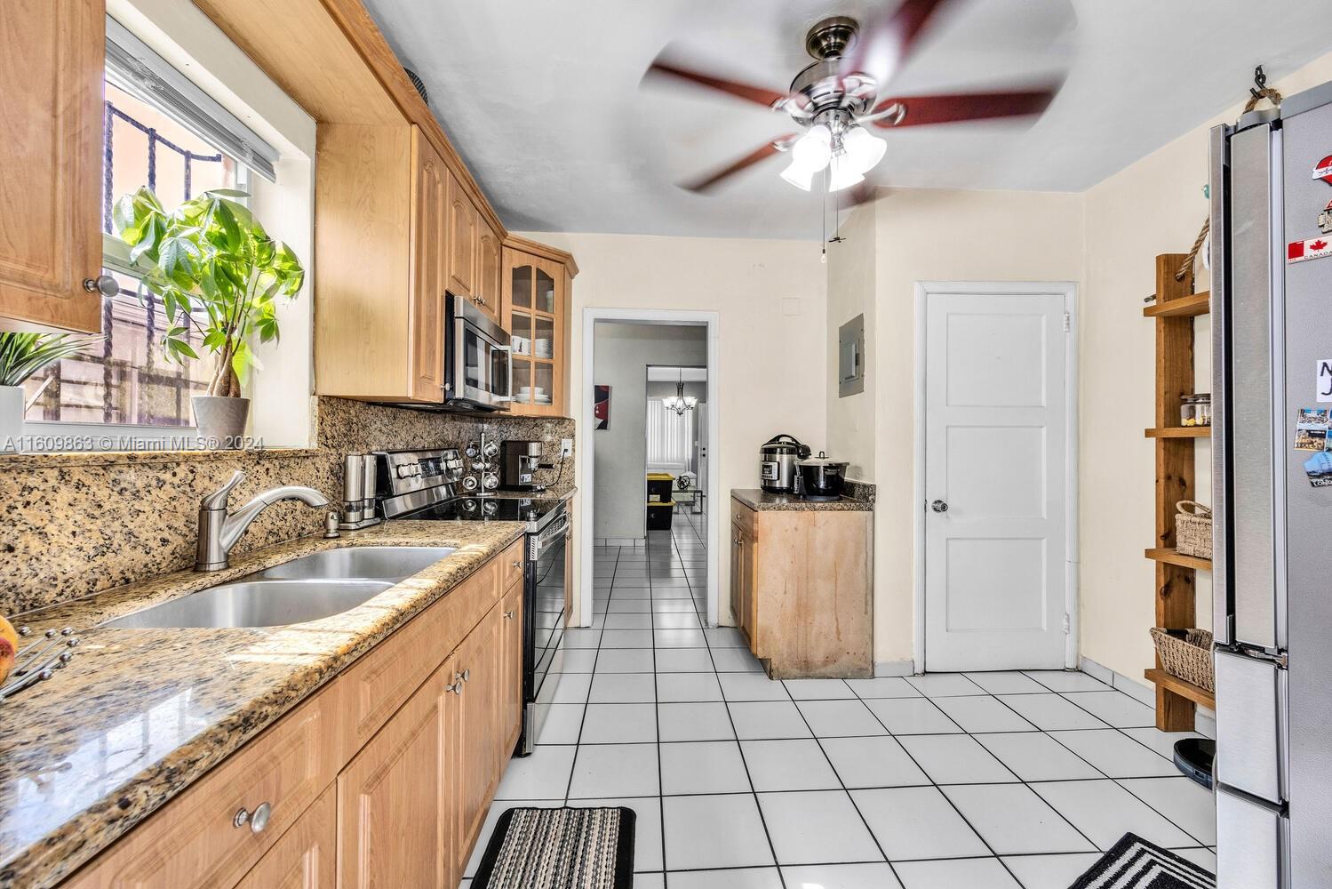 3430 Southwest 11th Street Miami, FL 33135 - Photo 6 of 21 a kitchen with a sink a stove cabinets and a window