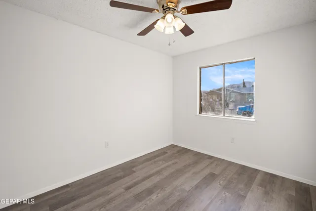 an empty room with a window and a ceiling fan