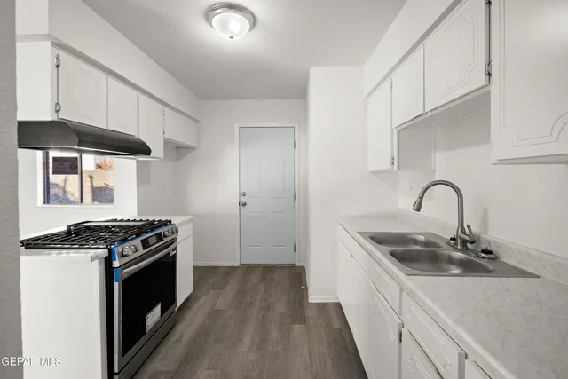 a kitchen with stainless steel appliances granite countertop a sink stove and cabinets