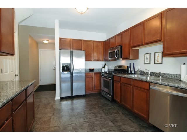 914 Oak Ridge Boulevard Elgin, IL 60120 - Photo 6 of 15 a kitchen with stainless steel appliances granite countertop a refrigerator a sink a stove a oven with wooden cabinets and floor