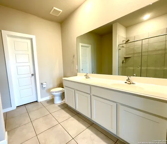 a bathroom with a double vanity sink mirror and toilet