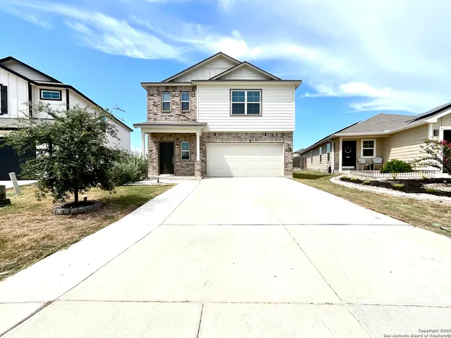 a view of a white house with large windows and palm trees