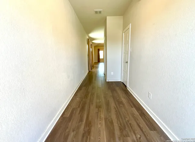 a view of a hallway with wooden floor