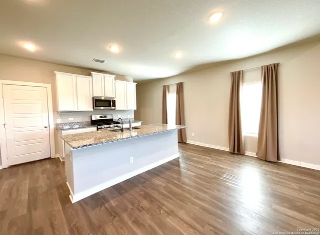 a view of kitchen with wooden floor and electronic appliances