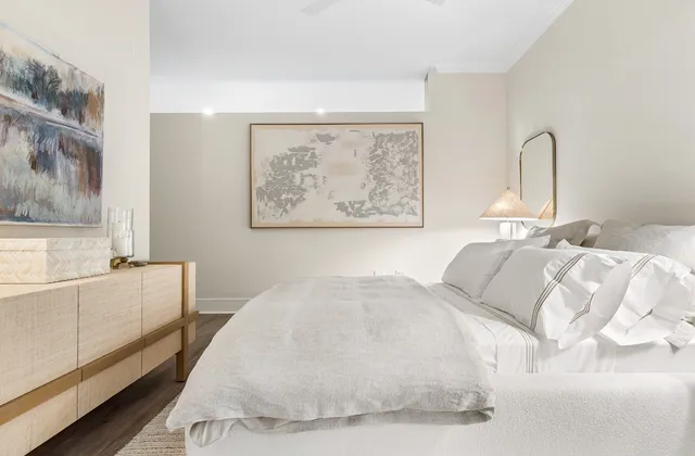 a bedroom with a bed and a painting on the wall