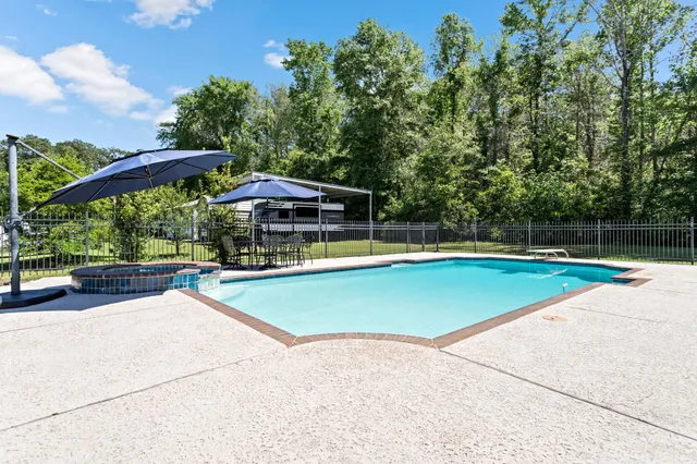 a view of a swimming pool with a yard and sitting area