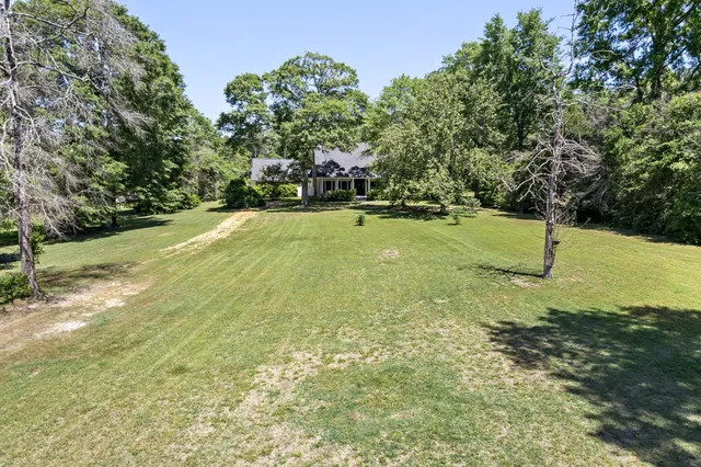 an aerial view of residential house with outdoor space and trees all around