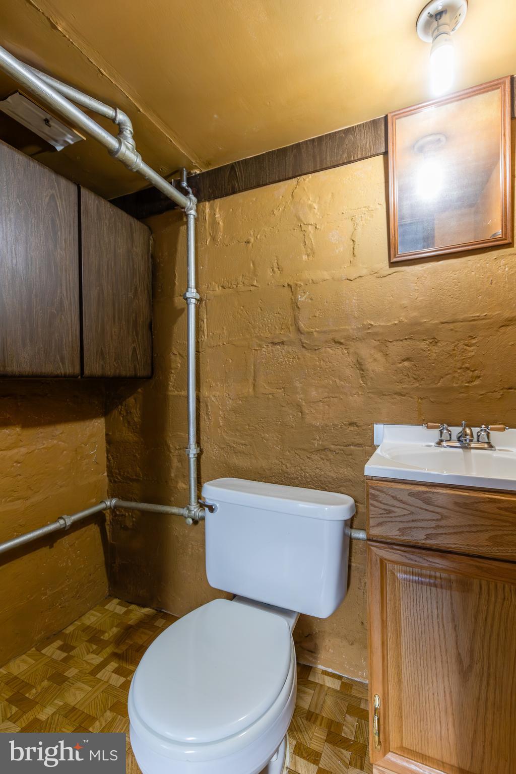 6426 Sherwood Road Baltimore, MD 21239 - Photo 31 of 43 a bathroom with a toilet a sink and mirror