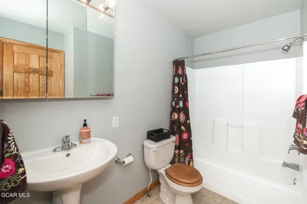 a white toilet sitting next to a bathroom sink and a shower