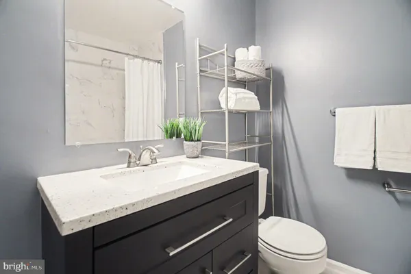 a bathroom with a sink a toilet a mirror and vanity