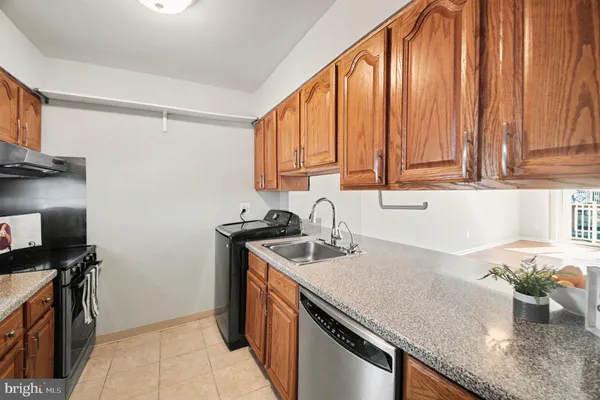 a kitchen with a sink a stove and cabinets