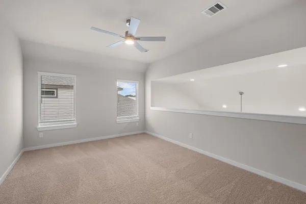 an empty room with windows and fan