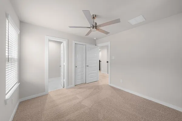 an empty room with fan and windows