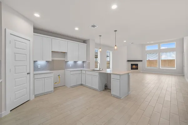 a large kitchen with a lot of counter space and wooden floor