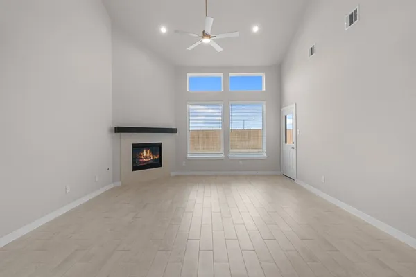 an empty room with windows and fireplace