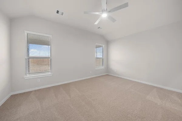 an empty room with a window and ceiling fan