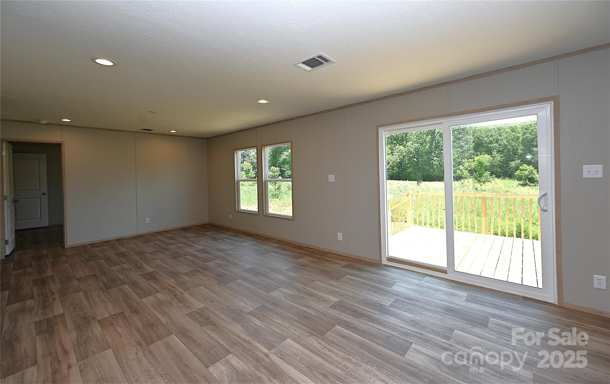 1213 Renno Road Clinton, SC 29325 - Photo 11 of 17 an empty room with wooden floor and windows