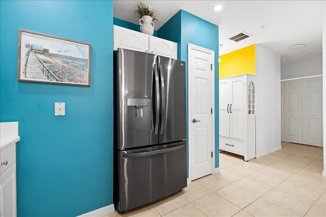 a view of kitchen with stainless steel appliances cabinets and a refrigerator