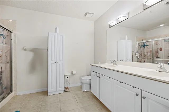 a spacious bathroom with a double vanity sink a mirror a shower and vanity