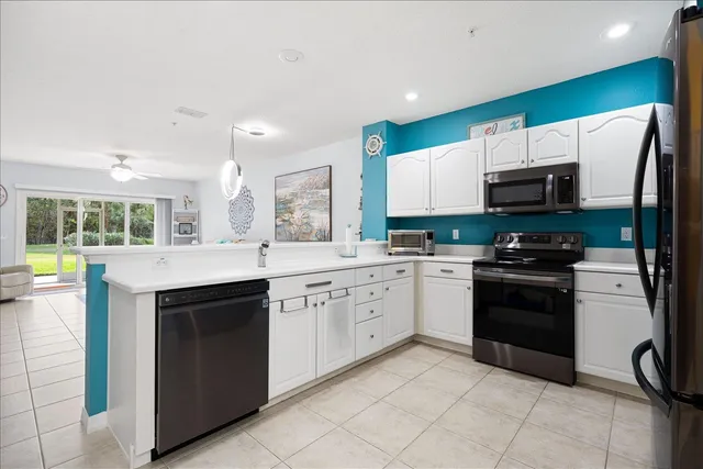 a kitchen with stainless steel appliances granite countertop a stove top oven a sink dishwasher and a refrigerator