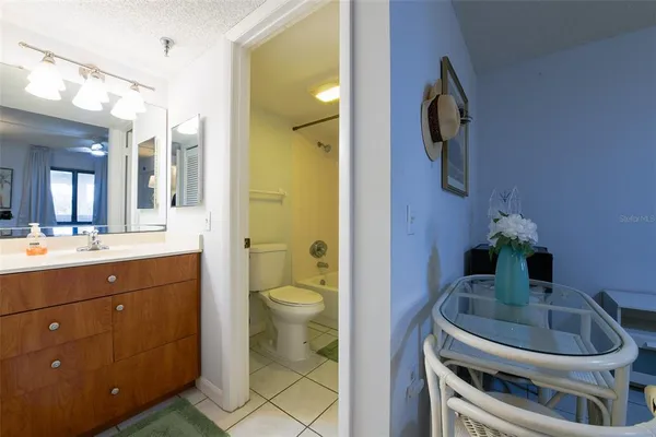 a balcony with chairs and a potted plant on a table