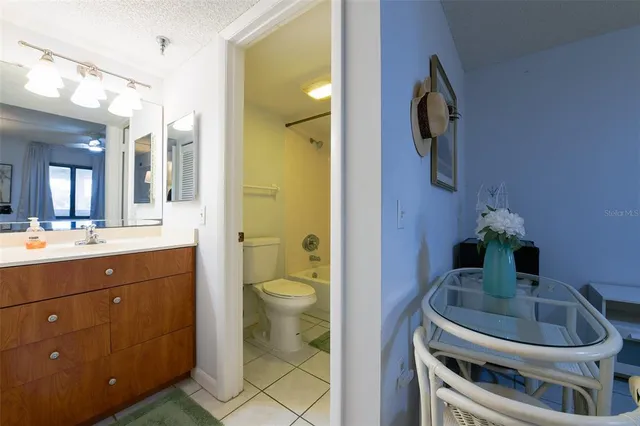 a balcony with chairs and a potted plant on a table